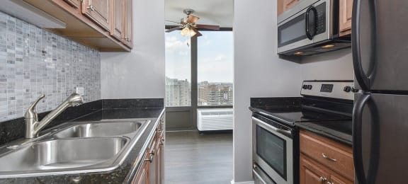 a kitchen with granite counter tops and stainless steel appliancesat The Montrose, Chicago