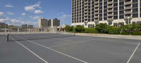an empty tennis court in front of a tall building at The Montrose, IL 60613