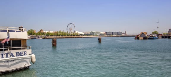 a boat in the water with a ferris wheel in the background at North Harbor Tower, Chicago, 60601