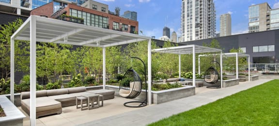 a grass patch with cabanas and buildings in the background at River North Park Apartments, Chicago, IL, 60654