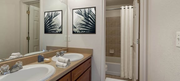 a bathroom with a sink and a mirror and a shower at Switchback on Platte Apartments, Littleton