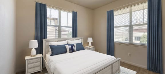 a bedroom with a bed and two windows at Switchback on Platte Apartments, Littleton, 80120