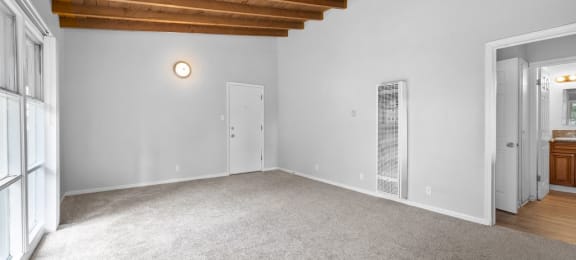 a living room with carpet and a door to a bathroom