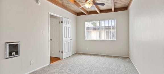 Luxury Apartments in Canoga Park - Parthenia Terrace - Large Bedroom with Ceiling Fan, Carpet, and Window with Blinds.