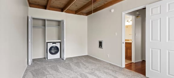 a bedroom with a ceiling fan and a washer and dryer
