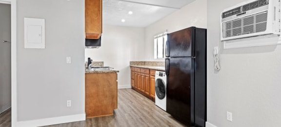 a kitchen with a black refrigerator freezer next to a stove top oven