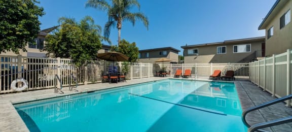 Canoga Park Luxury Apartments - Large Swimming Pool Surrounded by Lounge Chairs and Tables
