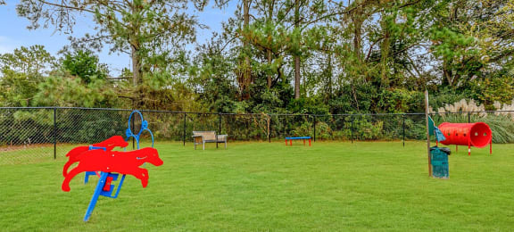 a grassy area with a playground and trees in the background at Planters Trace, South Carolina