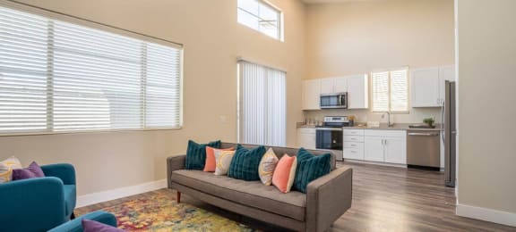 Furnished open floor plan living area has a couch and chairs in an apartment at Village Green of Queen Creek