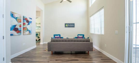 Wood-style flooring in a living room furnished with a couch at Village Greens of Queen Creek