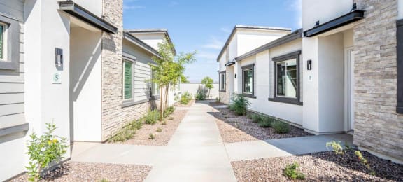 Landscaped walkways between the apartment homes at Village Greens of Queen Creek