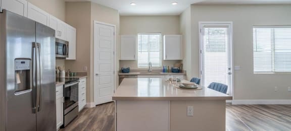 Open floor plan shows a kitchen with a large island in an apartment at Village Greens of Queen Creek