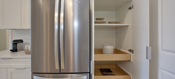 a kitchen with a refrigerator and some shelves