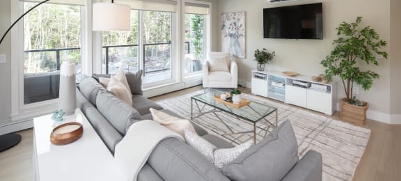 a living room with a gray couch and a white table