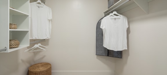 a walk in closet with a white shirt hanging on the wall