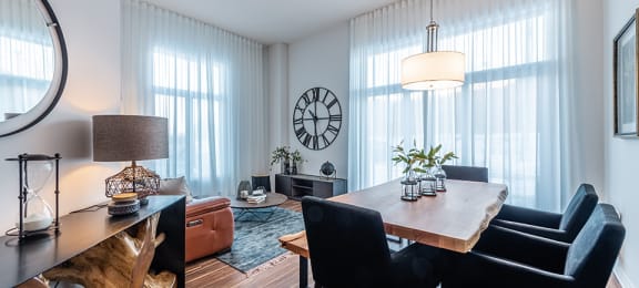 Brightly lit dining room with modern furnishings at La Voile Pointe-Claire apartments in Pointe-Claire, Quebec
