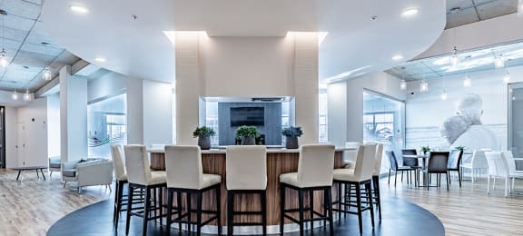 Private kitchen with circular bar in modern social room at La Voile Pointe-Claire apartments in Pointe-Claire, Quebec