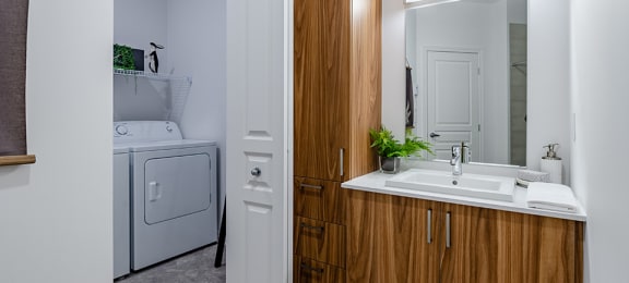 Modern bathroom featuring in-suite laundry at La Voile Pointe-Claire apartments in Pointe-Claire, Quebec
