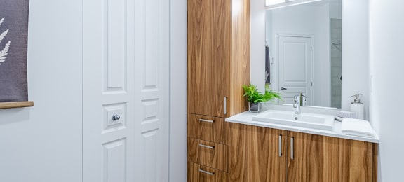 Modern bathroom with wood finishings at La Voile Pointe-Claire apartments in Pointe-Claire, Quebec