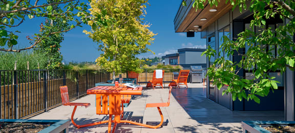 a patio with an orange table and orange chairs