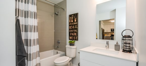 Bathroom with an oversized soaker tub, toilet and white vanity in a 1 bed 1 bath variation B in building A at Trio on Belmont in Kitchener, ON