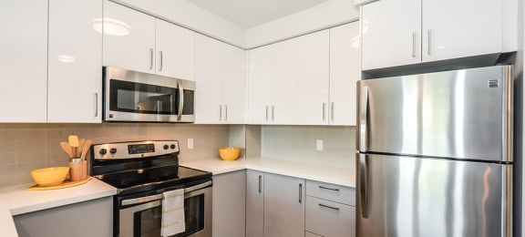 Kitchen with stainless steel appliances and white cabinets in a 1 bed 1 bath variation B in building A at Trio on Belmont in Kitchener, ON