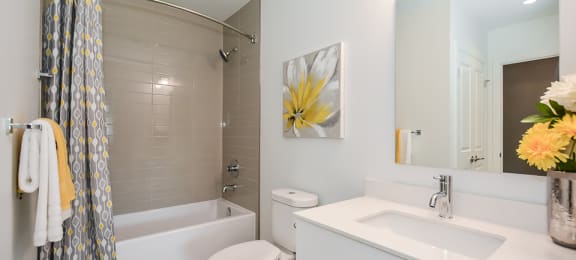 Primary bathroom with oversized soaker tub, toilet and white vanity in a 2 bed + den 2 bath variation E in building A at Trio on Belmont in Kitchener, ON
