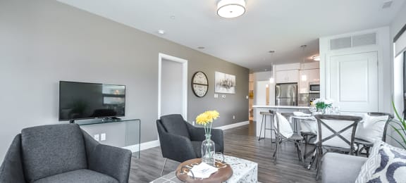 Open-concept living and dining area, looking towards kitchen, in a 2 bed + den 2 bath variation E in building A at Trio on Belmont in Kitchener, ON