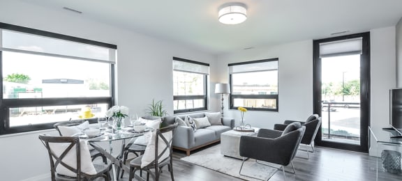 Open-concept dining and living area looking towards patio door in a 2 bed + den 2 bath variation E in building A at Trio on Belmont in Kitchener, ON