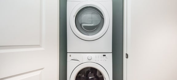 White stacked washer and dryer in-suite laundry in a 2 bed + den 2 bath variation E in building A at Trio on Belmont in Kitchener, ON