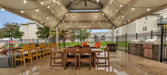 a patio with a table and chairs under a canopy