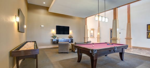 a spacious game room with a pool table and a foosball table