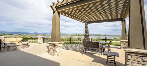 a patio with a pergola and a view of the water