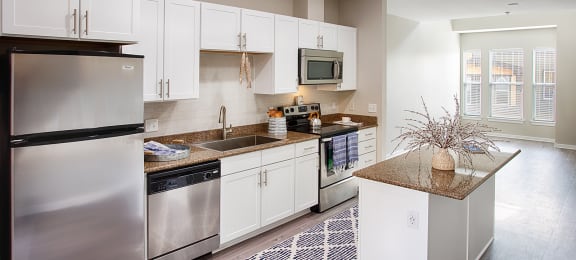 an open kitchen with stainless steel appliances and white cabinets