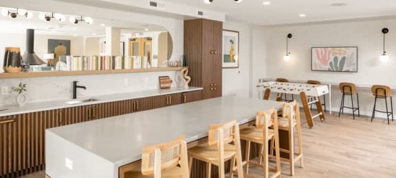 a kitchen with a long counter top and a dining room in the background