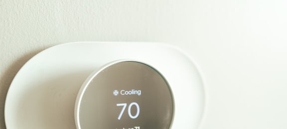 a digital thermostat on a white wall