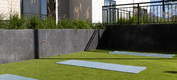a home gym with synthetic grass and concrete walls