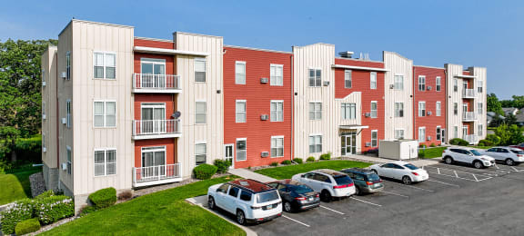 a picture of an apartment complex with cars parked in front of it