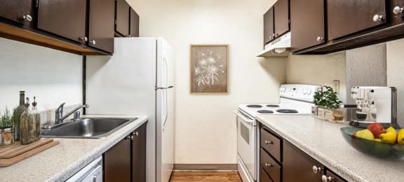 full kitchen with white appliances and wood flooring at the preserve