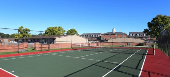 Tennis court with buildings in the background.