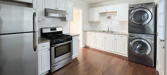 Kitchen with granite counters, wood floors, and washer dryer combo