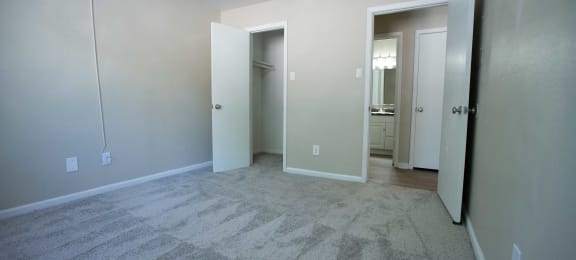 Rolling Brook Bedroom with carpet flooring, view into walk in closet and view into bathroom