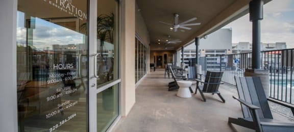 a covered patio with chairs and a glass door