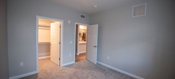 a bedroom with a closet and a door to a bathroom