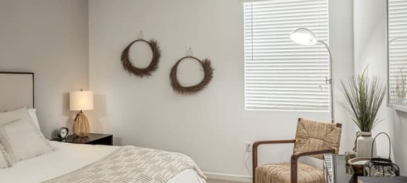 a bedroom with a bed and two wreaths on the wall