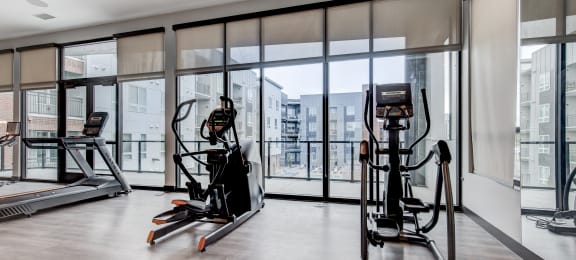 a gym with floor to ceiling windows and exercise equipment