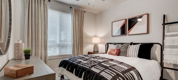 our apartments offer a bedroom with a large bed and a ceiling fan