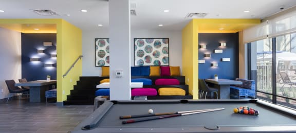 a pool table with a colorful couch in the background