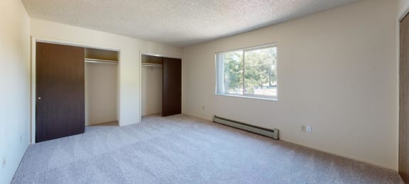 an empty bedroom with a large window and closet