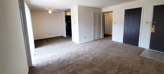 Living room with carpet and a door to a closet in a 1 bedroom apartment at Carriage House West.